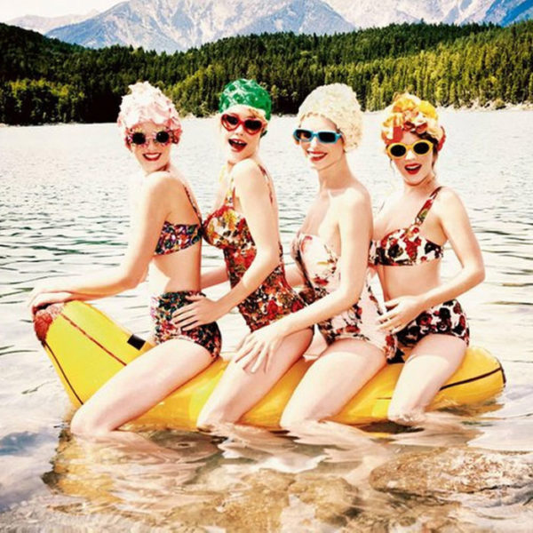 Banana Boat, heimat - cropped square by Ellen von Unwerth, four models in vintage bathing suits, sunglasses and swimcaps on a blow up banana