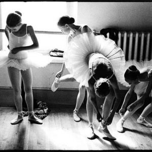 Young Vaganova Students Getting Ready, St. Petersburg. 1999 by Arthur Elgort, ballerinas in white tutus tieing their shoes