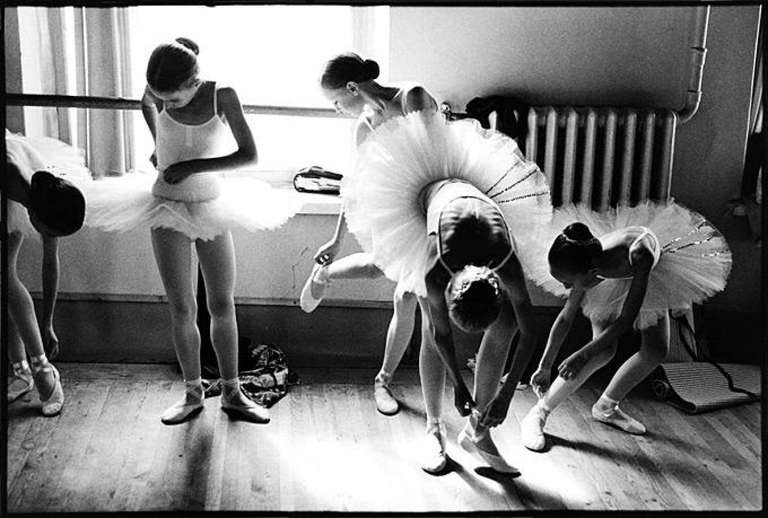 Young Vaganova Students Getting Ready, St. Petersburg. 1999 by Arthur Elgort, ballerinas in white tutus tieing their shoes