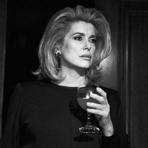 Catherine Deneuve 1996 by Michel Comte, black and white portrait of the actress holding a wine glass