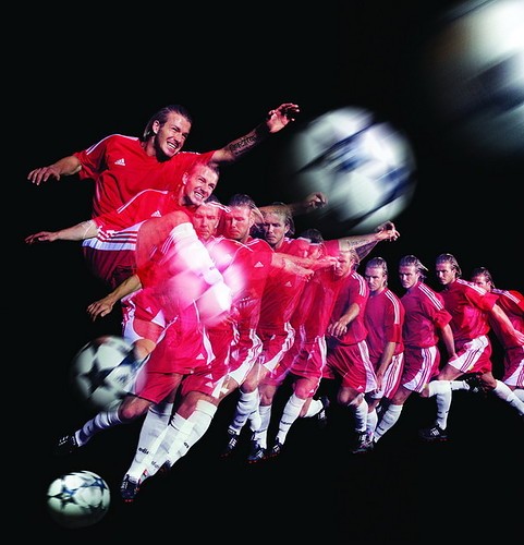 David Beckham by Howard Schatz, multiple exposure of the football star runnng at the ball and shooting, in red tricot
