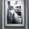 elizabeth hurley by Ellen von Unwerth, model in short metal dress standing in a kitchen smoking, framed black