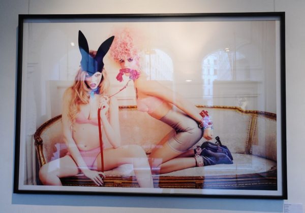 little beast by Ellen von Unwerth, two models in pink dessous on a sofa, one in a bunnear hat holding the other on a leash, framed black
