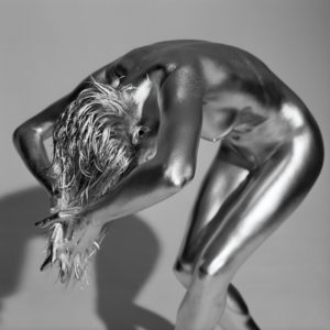 HERA by Guido Argentini, nude model painted silver bending over forwards