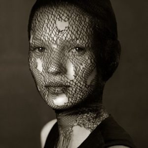 Kate Moss Veil by Albert Watson, black and white portrait of the model with a ripped veil over her face