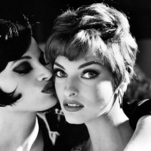 Kristen McMenamy and Linda Evangelista. 1991 by Arthur Elgort, two models in short hair, one kissing the other on the cheek
