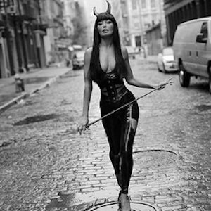 Sky Nellor, Crosb Street NYC by Sante D'Orazio, model in latex suit and devil horns, holding a whip walking on a street