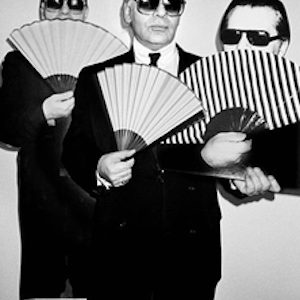 Three faces of Karl, NYC 1991 by Roxanne Lowit, the iconic fashion designer in suit and sunglasses, holding a fan, three times