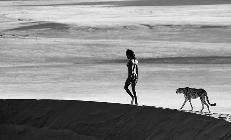 Girls on film by David Yarrow, nude model walking on a dune, a cheetah following her
