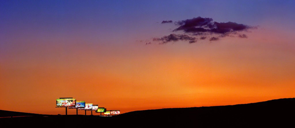 Vegas by Albert Watson, a row of Billboards in front of an orange sunset sky