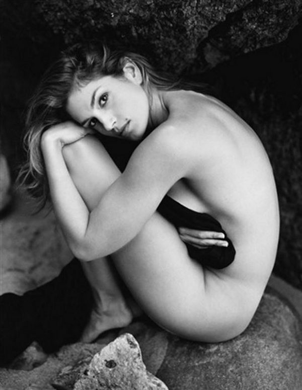 cindy crawford by Sante D'Orazio, the nude model crouching in sideprofile in a cave