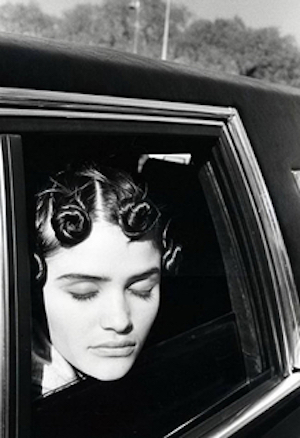 Helena Christensen. 1990 by Arthur Elgort, the model in tied up curlsenjoying the sun out of a carwindow with closed eyes