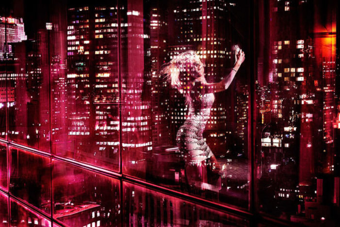 New York Selfie by David Drebin,window reflectioon of model in tight dress taking a slefie in pink light, a city at night in the back