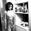 elizabeth hurley by Ellen von Unwerth, model in short metal dress standing in a kitchen smoking