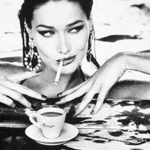 Carla Bruni by Ellen von Unwerth, the Model in a pool with an espresso cup, cigarette and big earrings