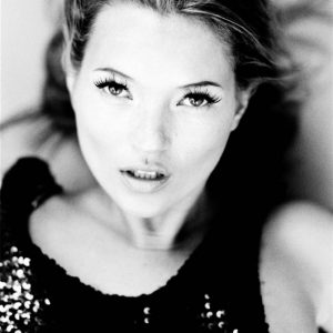 Kate Moss by Ellen von Unwerth, black and white portrait of the model lying down in a sequin top and one breast exposed