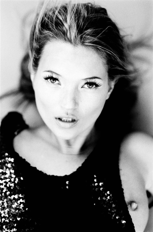 Kate Moss by Ellen von Unwerth, black and white portrait of the model lying down in a sequin top and one breast exposed