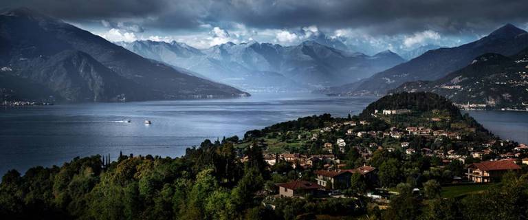 Escape to Lake Como by David Drebin, landscape of the lake with surrounding mountains and villages