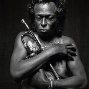 Miles Davis 1989 by Michel Comte, black and white portrait of the musician with his trumpet, eyes closed