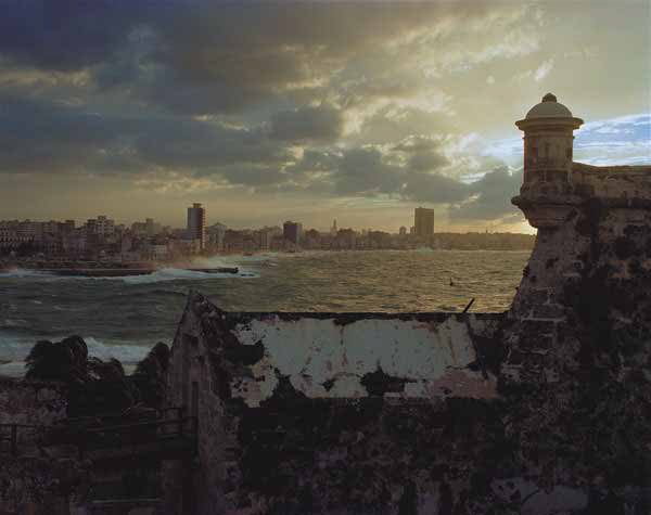 A view of Havana from the Castillo del Morro, by Robert Polidori, an old castello in the foreground and the coastlin of Havanna city in the background