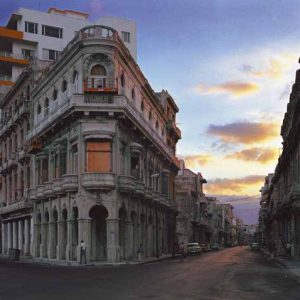 Avenida San Lazaro (from the Paseo del Prado), Centro Habana, Havana. 1997 by Robert Polidori, facade of an old cornerhouse with a modern house in the back and sunset clouds