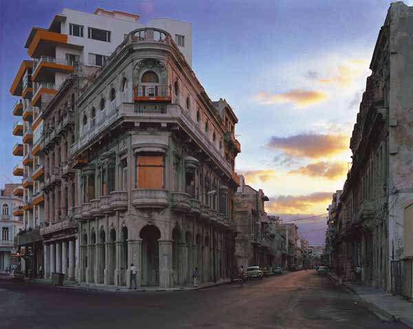 Avenida San Lazaro (from the Paseo del Prado), Centro Habana, Havana. 1997 by Robert Polidori, facade of an old cornerhouse with a modern house in the back and sunset clouds