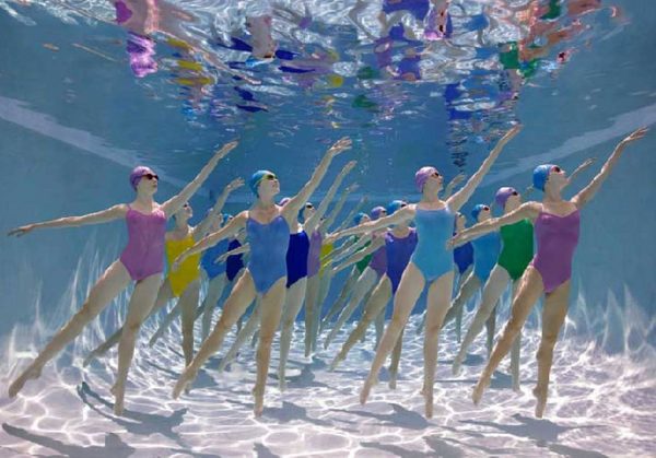 Corps du Ballet Underwater Study #3094 by Howard Scahtz, models in colorful simsuits and matching swimcaps and goggles dancing underwater in a pool