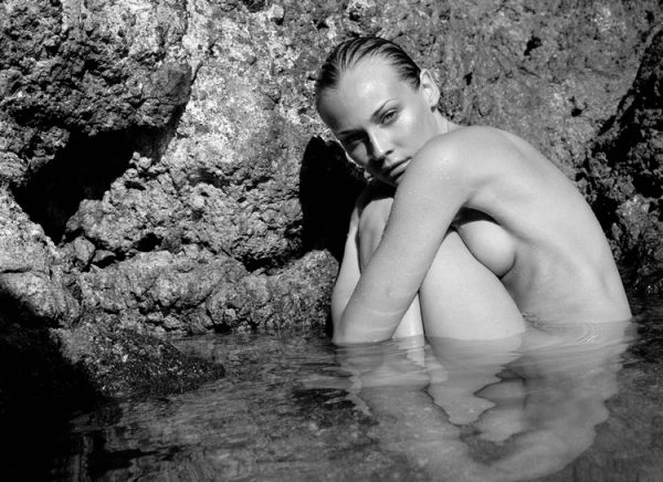 Diane Kruger by Antoine Verglas, the nude actress crouching in a natural pool betwenn rocks