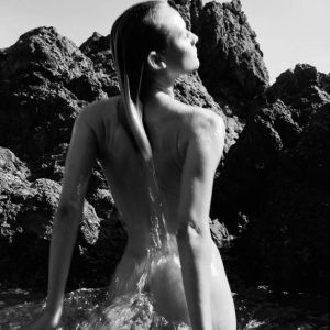 Diane Kruger II by Antoine Verglas, the nude actress jumping out of the water in a natural pool beteen Rocks