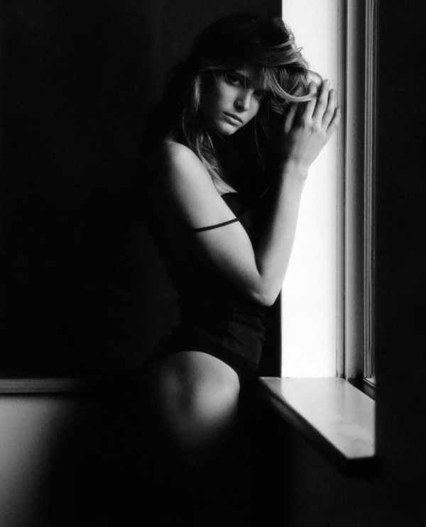 Stephanie Seymour II. 1989 by Antoine Verglas, model in black leotard standing by the window