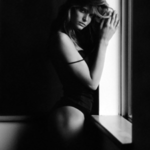 Stephanie Seymour II. 1989 by Antoine Verglas, model in black leotard standing by the window