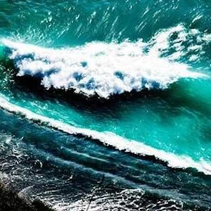 Crashing waves by David Drebin, coastline with turquoise waves crashing onto the black beach