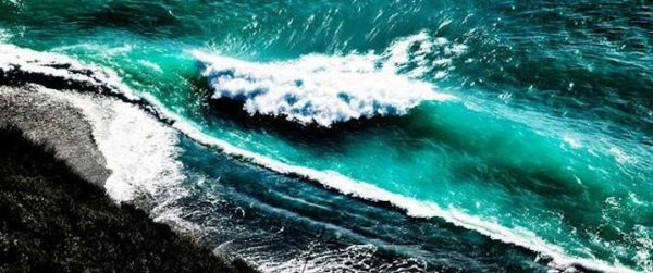 Crashing waves by David Drebin, coastline with turquoise waves crashing onto the black beach