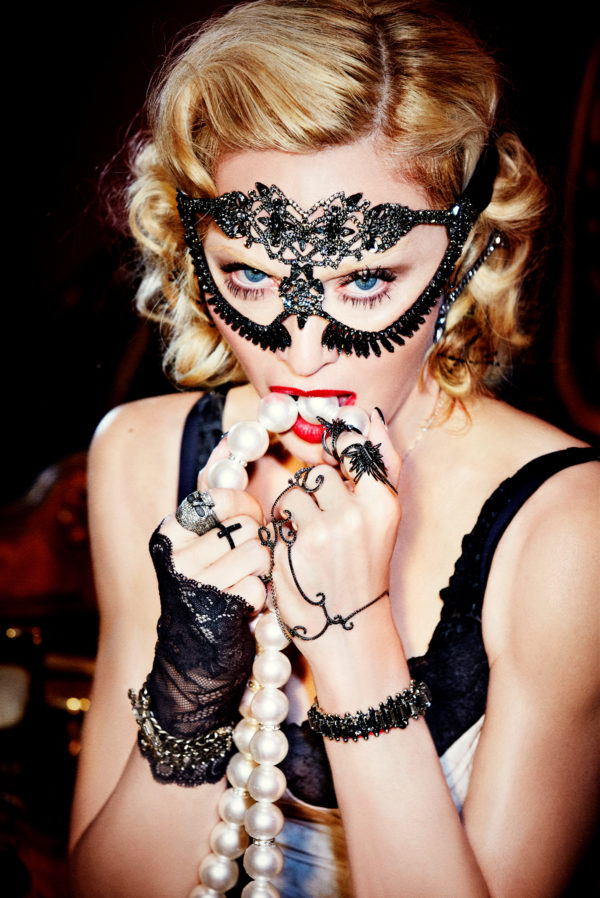 MATERIAL GIRL, MADONNA by Ellen von Unwerth, closeup portrait of the postar in a crystal mask and jewelry, biting a pearl necklace