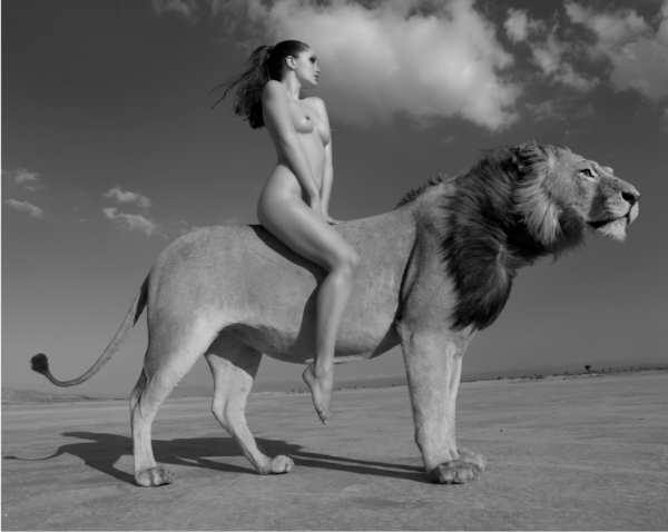 Angela Rides the Lion by Sylvie Blum, nude model sitting on a lions back in the desert