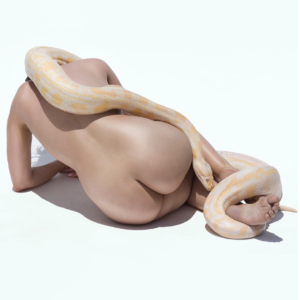 Giant Albino Python I. 2017 by Sylvie Blum, Nude model crouching on the floor, a white and yellow snake draped over her body