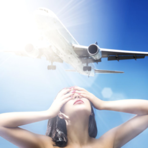 Airplane Lover by David Drebin, model holding her hands in front of her eyes while airplane flys above her in front of the blinding sun
