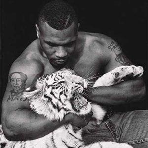 Mike Tyson by Sante D'orazio, the boxer in jeans and shirtless, holding a young snowtiger
