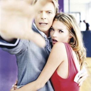 David Bowie & Kate Moss, Colour by Ellen von Unwerth, Bowie and Moss hugging while Bowie is trying to shield them from the camera