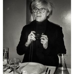 Andy Warhol, NY 1985 by Roxanne Lowit, the artist sitting at a