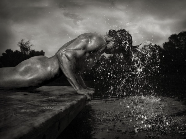 Patrick II by Andreas H. BItesnich, nude male model doing a pushap next to a pool, water dripping from his head