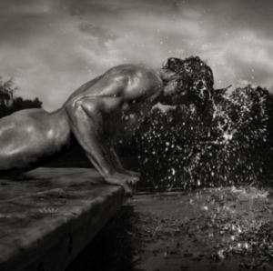 Patrick II by Andreas H. BItesnich, nude male model doing a pushap next to a pool, water dripping from his head