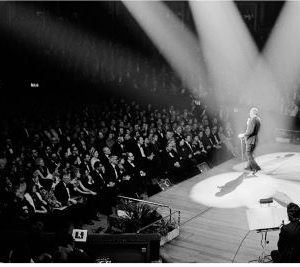 Frank Sinatra at the Royal Albert Hall by Terry O'Neill, the famous singer in front of his audience, illuminated by three bright spotlights