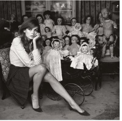 Jean Shrimpton by Terry O'neil, Model sitting next to a stack of old dolls