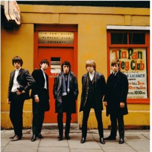 Rolling Stones Tin Pan Alley, the band in front of a yellow and red shopfront