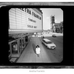 Aretha Franklin by Timothy White, the singer ina white dress standing under a sign announcing her sold out show