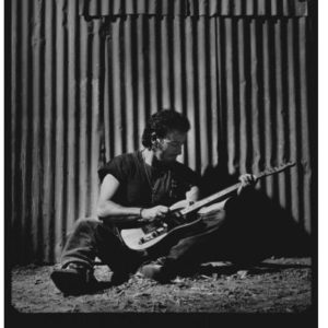 Bruce Springsteen by Timothy White, the musician sitting with his guitar