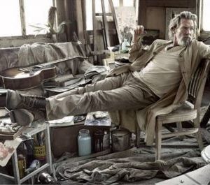 Jeff Bridges by Mark Seliger, the actor dressed in brown and beige in a meassy artstudio