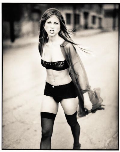 Jennifer Aniston, Los Angeles, CA, 1999 by Mark Seliger, the actress in black lingerie and stockings with transparent blouse wakling on a street with an angry expression