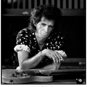 Keith Richards by Timothy, black and white portrait of the musician in a graphic shirt with his guitar